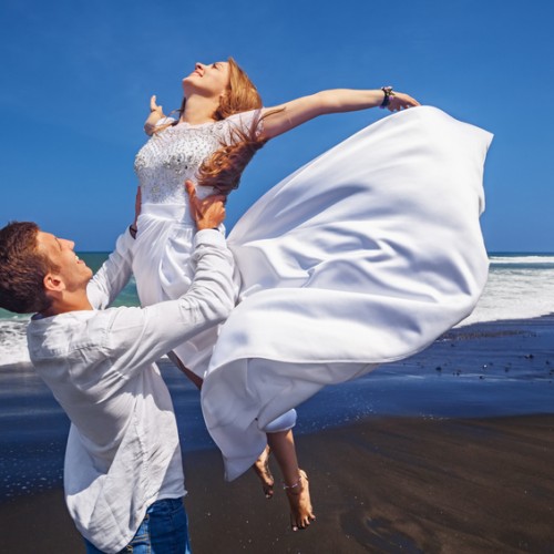 Young loving couple have fun on sea black sand beach